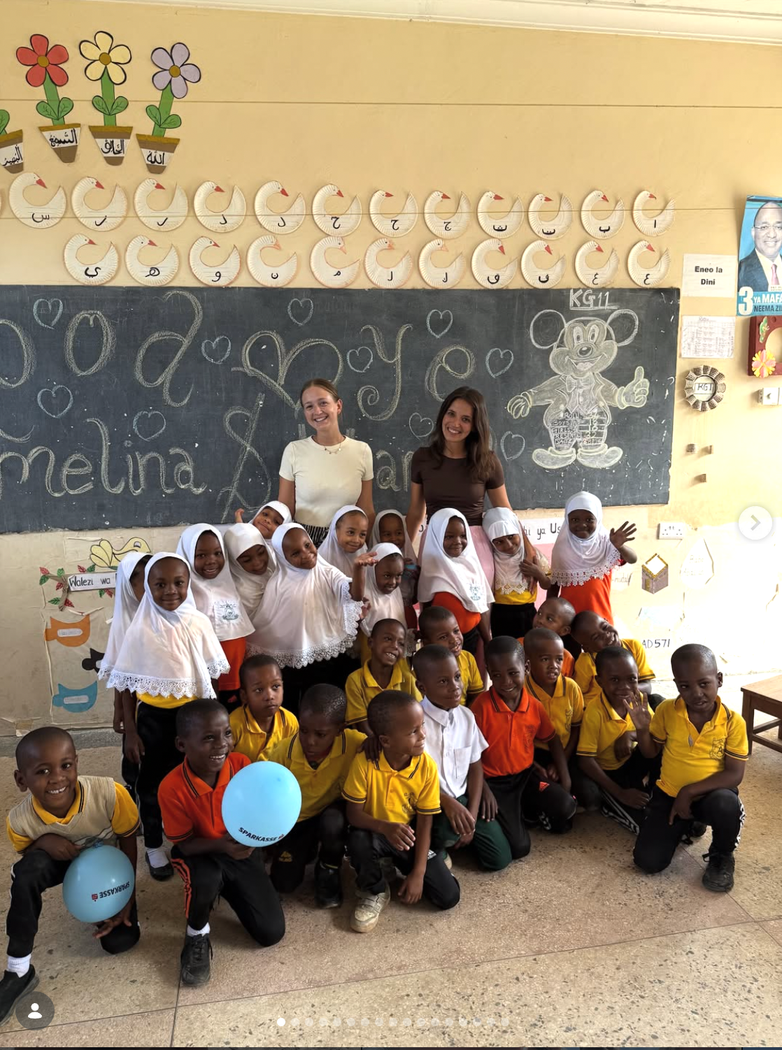 Volunteers teaching in a classroom with Tanzanian schoolchildren and blue balloons
